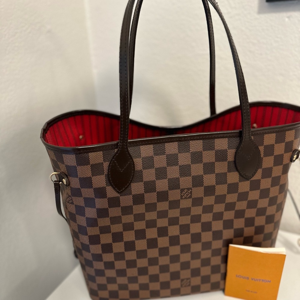 The Neverfull MM tote in Damier Ebene canvas with natural cowhide.